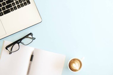 Siyah ve beyaz dizüstü bilgisayar klavye minimalist düz yatıyordu kompozisyon, fincan kahve ve katlanmış gözlük, boş sayfaları defter, kalem, Resepsiyon Masa arka plan mavi. Çalışma alanı üstten görünüm, kopya alanı