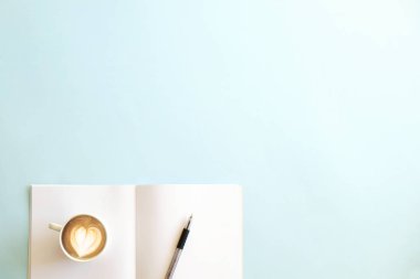 Kağıt defter sayfaları için yaratıcı fikirler plank ve planlama, kalem ve beyaz fincan cappuccino kahve kalp latte sanat ile mürekkep. Yaratıcı yazarlık kavramı. Arka plan, uzay kopyalama, en iyi görünümü kapatın, yat.