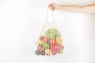 Tanınmayan oung kadının el karışık meyve, sebze ve yeşillik bir torba tutarak: Mısır Mısır koçanı, domates, biber, marul, armut ve elma. Sıfır atık kavramı. Beyaz duvar arka plan, kopya alanı, yakın çekim.