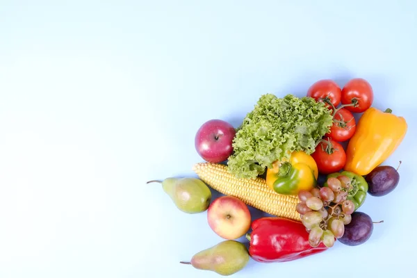 Clean healthy eating habits concept. Fruits, vegetables and greens mix on white blue background. Pepper, tomato, lettuce, corn cob, pear & apple, plum. Vegan vegetarian diet food. Flat lay copy space