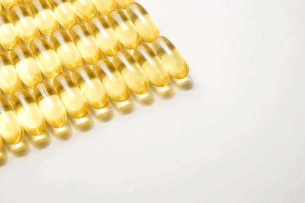 一束欧米茄3鱼肝油胶囊成排形成模式的背景 关闭大的金色半透明药丸质地 健康的每一天营养补充 顶部视图 平面放置 复制空间 — 图库照片