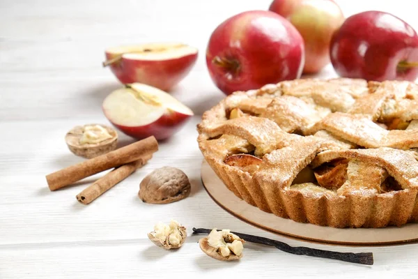 Traditional American Thanks Giving pie, whole & halved apples, cinnamon sticks, anise seeds. Homemade fruit tart baked to golden crust with ingredients. Close up, copy space, top view, background.