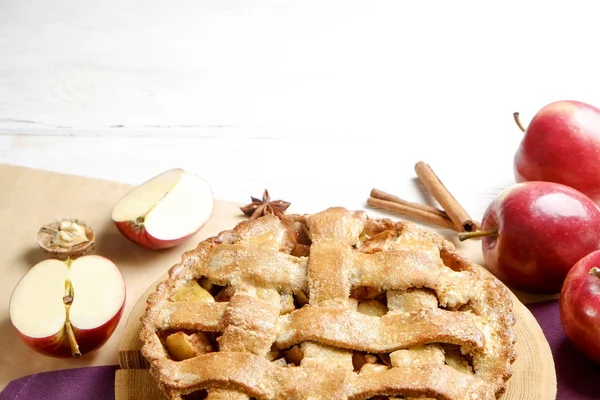 Traditional American Thanks Giving pie, whole & halved apples, cinnamon sticks, anise seeds. Homemade fruit tart baked to golden crust with ingredients. Close up, copy space, top view, background.