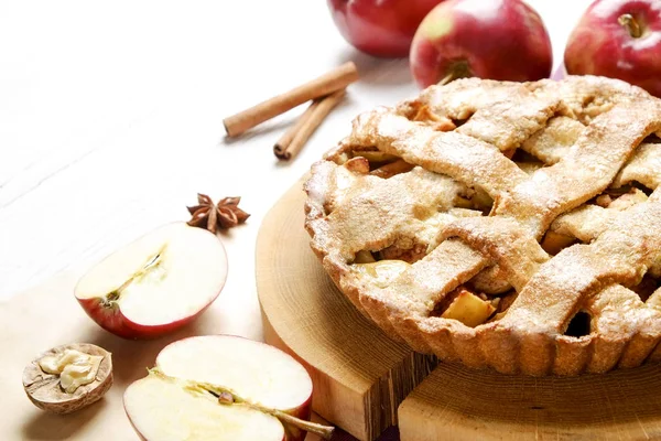 Traditional American Thanks Giving pie, whole & halved apples, cinnamon sticks, anise seeds. Homemade fruit tart baked to golden crust with ingredients. Close up, copy space, top view, background.