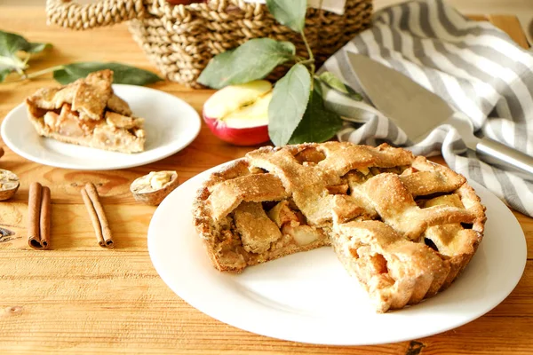 Traditional American Thanks Giving pie, whole & halved apples, cinnamon sticks, anise seeds. Homemade fruit tart baked to golden crust with ingredients. Close up, copy space, top view, background.