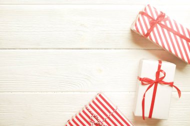 Üç Noel wrappend kırmızı ve beyaz kağıt baker sicim dize ve ipek yay ile bağlı sunar. Farklı ambalaj birden çok yeni yıl hediyeleri. Ana sayfa görünümü, yakın çekim, kopya alanı, arka plan, düz lay