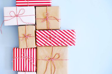 Noel çok kırmızı, beyaz ve craft kağıt baker sicim dize ile bağlı wrappend sunar. Farklı ambalaj birden çok yeni yıl hediyeleri. Ana sayfa görünümü, yakın çekim, kopya alanı, arka plan, düz lay.