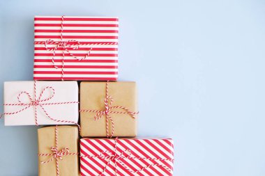 Noel çok kırmızı, beyaz ve craft kağıt baker sicim dize ile bağlı wrappend sunar. Farklı ambalaj birden çok yeni yıl hediyeleri. Ana sayfa görünümü, yakın çekim, kopya alanı, arka plan, düz lay.