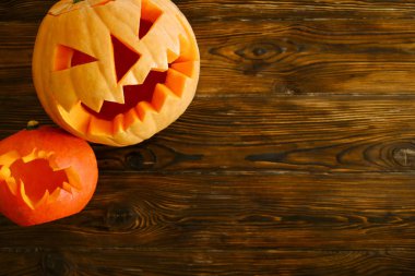 Jack o fener ve ahşap masa üzerinde döşeme yarasa şeklinde küçük bir büyük turuncu kabak oyulmuş. Arka plan, uzay kopyalayın, yakın çekim, görünümü top. Tüm toplantı salonu Havva Cadılar Bayramı partisi dekorasyon konsepti.