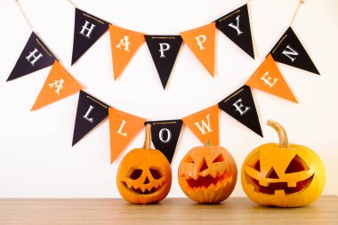 Farklı büyüklükte birkaç Turuncu kabak Jack o fener ahşap masa üzerinde oyulmuş. Arka plan, uzay kopyalayın, yakın çekim, görünümü top. Tüm eve Cadılar Bayramı partisi dekorasyon toplantı salonu. Ya parani ya canini kavramı.