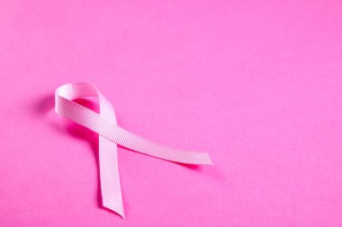 Pembe renkli kurdele - meme kanseri bilinçlendirme ve kadınlar için moral desteği uluslararası sembolü. İzole arka plan, kopya alanı, yakın çekim, görünümü şişman lay top.