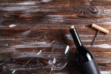 Vintage şişe boş mat siyah etiketli, tirbuşon grunged ahşap masa arka plan üzerinde kırmızı şarap. Pahalı bir şişe cabernet sauvignon kavramı. Kopyalama alanı, üstten görünüm, düz lay.