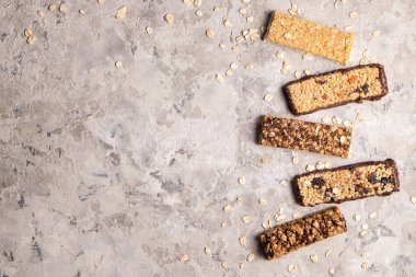 Kurutulmuş meyve ve çeşitli fındık, gri beton zemin ile karışık gluten ücretsiz granola tahıl enerji bar. Sağlıklı vegan süper yiyecek, sportif yaşam tarzı için çerez Diyet fitness. Üstten görünüm, kopya alanı.