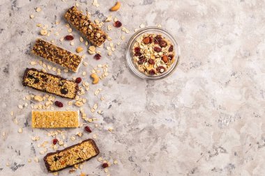 Kurutulmuş meyve ve çeşitli fındık, gri beton zemin ile karışık gluten ücretsiz granola tahıl enerji bar. Sağlıklı vegan süper yiyecek, sportif yaşam tarzı için çerez Diyet fitness. Üstten görünüm, kopya alanı.