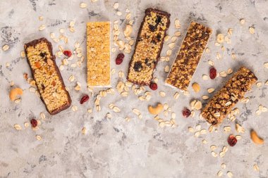 Kurutulmuş meyve ve çeşitli fındık, gri beton zemin ile karışık gluten ücretsiz granola tahıl enerji bar. Sağlıklı vegan süper yiyecek, sportif yaşam tarzı için çerez Diyet fitness. Üstten görünüm, kopya alanı.