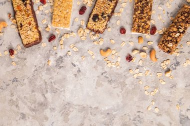 Kurutulmuş meyve ve çeşitli fındık, gri beton zemin ile karışık gluten ücretsiz granola tahıl enerji bar. Sağlıklı vegan süper yiyecek, sportif yaşam tarzı için çerez Diyet fitness. Üstten görünüm, kopya alanı.