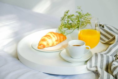 Yatak konsepti Odaya Servis Kahvaltı. Bardağı taze portakal suyu, kahve ve Fransız kruvasan simit, fincan dolu ile beyaz tepsi battaniye çıkardı. Üstten görünüm, arka plan, kapatmak, alanı Kopyala.