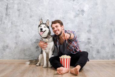 Genç sakallı adam dışarı asılı dışarı ile onun husky köpek. Hippi erkek damalı pazen gömlek ve gri dört bacaklı evde beslenen hayvan arkadaş ile kaliteli zaman geçirmek tişört giyiyor. Yakın çekim, uzay, arka plan kopya