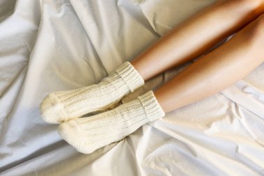 Yumuşak tenli uzun kadın bacakları. Beyaz yatağın iç tarafındaki tüyler alındıktan sonra kusursuz sağlıklı ipek bacaklı bir kadın derisi. Güzellik, cilt bakımı konsepti. Yüksek Çözünürlük.