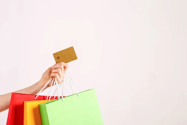 女性手拿着一堆不同五颜六色的空白购物袋与金色无限的信用卡在孤立的白色背景的短款拍摄 黑色星期五销售概念 复制空间 — 图库照片