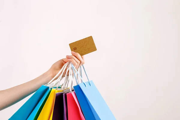 女性手拿着一堆不同五颜六色的空白购物袋与金色无限的信用卡在孤立的白色背景的短款拍摄 黑色星期五销售概念 复制空间 — 图库照片