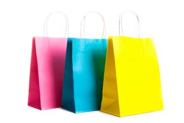 Birçok boş kağıt poşetler, farklı renkler, pembe, mavi ve beyaz arka plan üzerinde izole sarı. Boş renkli paket. Siyah Cuma satış konsepti. Kopyalama alanı kapatın.