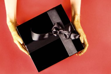 Güzel minimalist multi amaç kompozisyon hediye kutusu tutan kadın ile sarılmış ve saten kurdele ile bağlanmış. Tatil dişinin kollarında mevcut. Arka plan, uzay kopyalama, en iyi görünümü kapatın, yat.