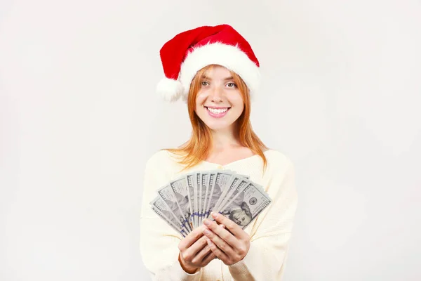 Money as a Christmas present concept. Portrait of happy young redheaded woman holding bunch of one hundred dollar bills received as new years gift. White isolated background, copy space, close up. — Stock Photo, Image