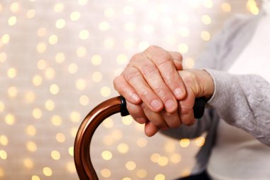 Yaşlı kadın kutlama Noel evde, süslü tatil çam ağacı üzerinde arka plan ile. Huzurevi yaşlı kadına. Yakın çekim, atış kırpılmış alanı Kopyala.