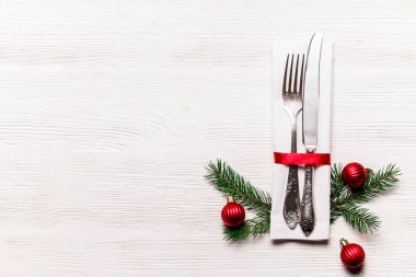 Çatal, bıçak ve şenlikli öznitelikleri ile Noel tablo ayarı kavramsal tasarım. Yeni yıl ziyafet çatal bıçak ile randevu seçenekleri sunan. Arka plan, üstten görünüm, düz yatıyordu kapatın, alanı Kopyala.