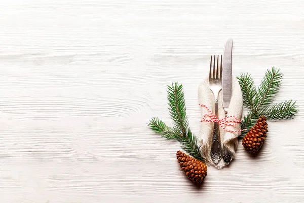 Christmas table setting conceptual design with fork, knife and festive attributes. New Year banquet serving appointment options with silverware. Background, close up, top view, flat lay, copy space.