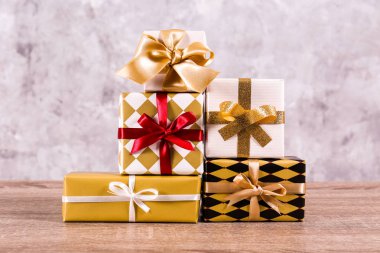 Noel hazırlık kavram. Her aile membet için farklı renkli presents yığını. Parlak Festival hediyeleri yığını kaydırma. Yakın çekim, uzay grunged beton duvar arka plan kopya.