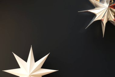 Kopya alanı metin için bir sürü renkli arka plan üzerinde beyaz kağıt yıldız ile minimalist kompozisyon. Üstten görünüm, düz yatıyordu, portre. Noel ruhu kavramı ile pırıltı yıldız.