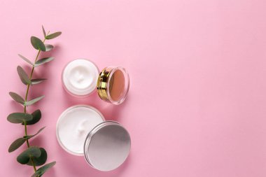 Bakım cilt bakımı yüz kremi karmaşık şifa için Nemlendirici Cilt tipi görünür doku ile açık bir kavanoza sorunlu. Kopya alanı, yakın çekim, arka plan, düz yatıyordu, en iyi görünüm. Okaliptüs yaprağı dekorasyon.