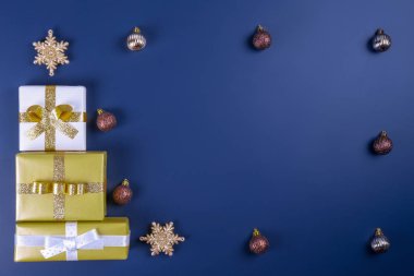 Renkli Noel ile şenlikli kompozisyon yay üzerinde düz mavi arka plan ile bağlı sarılmış parlak kağıt sunar. Yılbaşı temalı düz lay şenlikli öznitelikleri ile. Yakın çekim, alanı Kopyala.