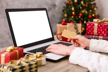 Altın kredi kartı, dizüstü bilgisayar, Noel hediyesi, bir şekilde dekore edilmiş ağaç arka plan üzerinde eller. Malzeme çekme kadın online, eshopping üstünde onu laptop sunar. Ahşap masa, kopya alanı, kapat.