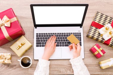 Altın kredi kartı, dizüstü bilgisayar, Noel hediyesi, bir şekilde dekore edilmiş ağaç arka plan üzerinde eller. Malzeme çekme kadın online, eshopping üstünde onu laptop sunar. Ahşap masa, kopya alanı, kapat.
