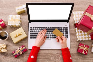 Altın kredi kartı, dizüstü bilgisayar, Noel hediyesi, bir şekilde dekore edilmiş ağaç arka plan üzerinde eller. Malzeme çekme kadın online, eshopping üstünde onu laptop sunar. Ahşap masa, kopya alanı, kapat.