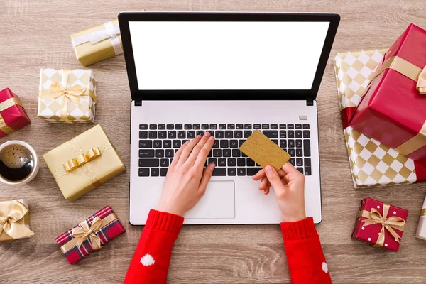Altın kredi kartı, dizüstü bilgisayar, Noel hediyesi, bir şekilde dekore edilmiş ağaç arka plan üzerinde eller. Malzeme çekme kadın online, eshopping üstünde onu laptop sunar. Ahşap masa, kopya alanı, kapat.