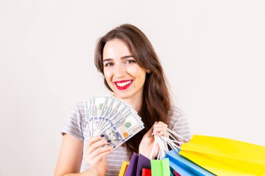 İlkbahar Yaz sezonu Satılık kavramı. Uzun esmer saçlı çekici genç kadın, ince giyiyor rahat gömlek, beyaz arka plan üzerinde birçok farklı boş alışveriş torbaları tutan uygun. Uzay kopyalayın, yakın çekim