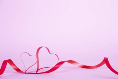 Parlak beyaz arka plan üzerinde kalp şeklinde izole ipek kurdele koydu. Festival dekorasyon. Anne, kadın, evlilik, mutlu st Sevgililer günü kavramı, 14 Şubat. Üstten görünüm, düz yerde kal, yakın çekim.
