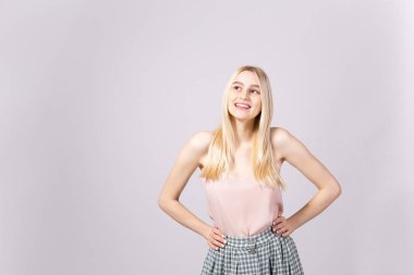 Stüdyo uzun düz saç yumuşak pembe üst ve yenilikçi tam boyu yüksek belli Damalı etek giyen genç sarışın kadınla muhteşem bir kadeh. İzole arka plan gri, uzay kopyalayın, portre, kapatmak.