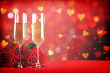 Kırmızı kalp üzerinde iki şampanya flüt gözlüklü kavramsal görüntü bokeh ışıklar şeklinde. Romantik akşam yemeği st Sevgililer günü için. Yakın çekim, alanı Kopyala. Farklı romantik günler için renkli arka plan