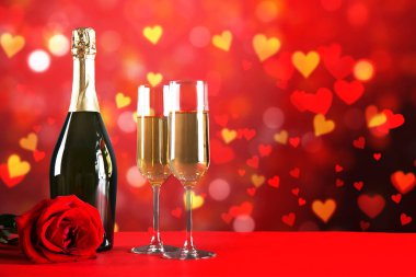 Kırmızı kalp üzerinde iki şampanya flüt gözlüklü kavramsal görüntü bokeh ışıklar şeklinde. Romantik akşam yemeği st Sevgililer günü için. Yakın çekim, alanı Kopyala. Farklı romantik günler için renkli arka plan