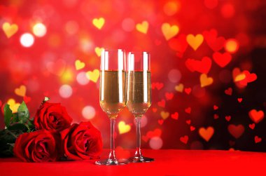 Kırmızı kalp üzerinde iki şampanya flüt gözlüklü kavramsal görüntü bokeh ışıklar şeklinde. Romantik akşam yemeği st Sevgililer günü için. Yakın çekim, alanı Kopyala. Farklı romantik günler için renkli arka plan