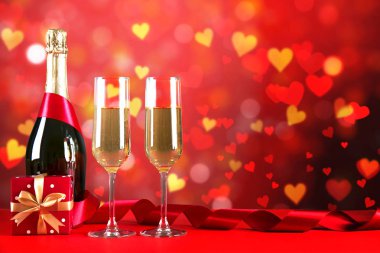 Kırmızı kalp üzerinde iki şampanya flüt gözlüklü kavramsal görüntü bokeh ışıklar şeklinde. Romantik akşam yemeği st Sevgililer günü için. Yakın çekim, alanı Kopyala. Farklı romantik günler için renkli arka plan