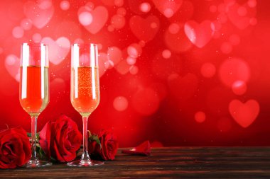 Kırmızı kalp üzerinde iki şampanya flüt gözlüklü kavramsal görüntü bokeh ışıklar şeklinde. Romantik akşam yemeği st Sevgililer günü için. Yakın çekim, alanı Kopyala. Farklı romantik günler için renkli arka plan