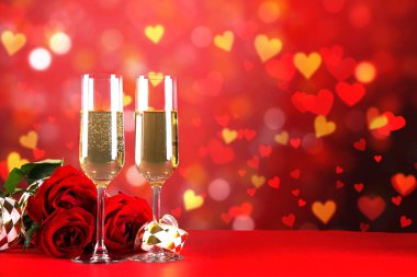 Kırmızı kalp üzerinde iki şampanya flüt gözlüklü kavramsal görüntü bokeh ışıklar şeklinde. Romantik akşam yemeği st Sevgililer günü için. Yakın çekim, alanı Kopyala. Farklı romantik günler için renkli arka plan