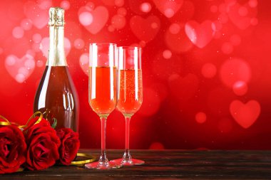 Kırmızı kalp üzerinde iki şampanya flüt gözlüklü kavramsal görüntü bokeh ışıklar şeklinde. Romantik akşam yemeği st Sevgililer günü için. Yakın çekim, alanı Kopyala. Farklı romantik günler için renkli arka plan