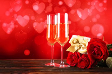 Kırmızı kalp üzerinde iki şampanya flüt gözlüklü kavramsal görüntü bokeh ışıklar şeklinde. Romantik akşam yemeği st Sevgililer günü için. Yakın çekim, alanı Kopyala. Farklı romantik günler için renkli arka plan